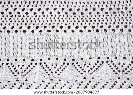 White textured background of openwork knitted fabric. Royalty-Free Stock Photo #2087904697