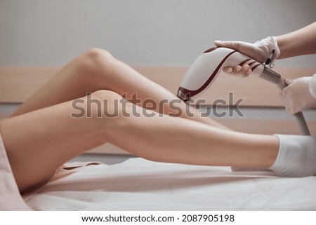 Young woman getting laser hair removal on her thighs.