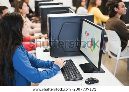 Young students using computers during business class at school - Focus on girl hands