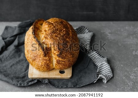 yeast-free sourdough bread. a beautiful European woman baker holds bread in her hands. bake bread for lunch or for sale. a recipe for healthy and delicious bread for the whole family. bakery or