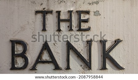 Bank Stone Sign. Retro styled image of an old bank sign carved in a concrete wall. Street view, nobody, selective focus, travel photo