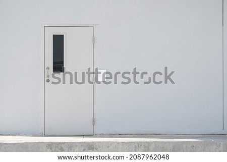 external shut doors on a white wall. White Door on White Wall