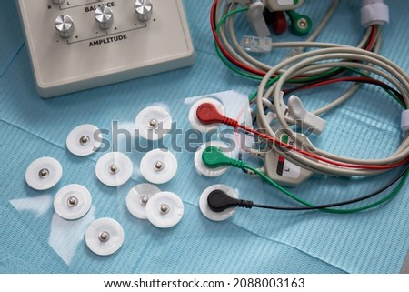 Device for neuromuscular stimulation of temporomandibular joint with wires and electrodes on the table Royalty-Free Stock Photo #2088003163