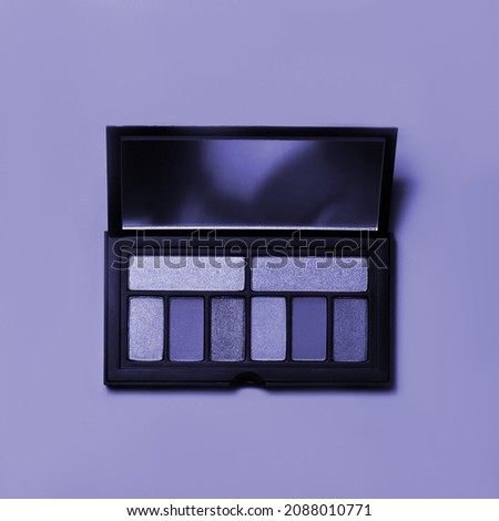 Various makeup products on dark background with copyspace. New 2022 trending PANTONE 17-3938 Very Peri color
