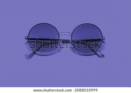 Beautiful trendy sunglasses on a pink background. New 2022 trending PANTONE 17-3938 Very Peri color
 Royalty-Free Stock Photo #2088010999