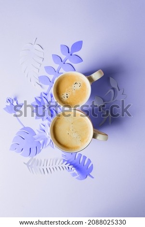 Cup of coffee on papercraft ultraviolet purple flowers, origami handmade. Concept of good morning, feminine routine, trendy color of the year 2022, Woman Day 8 march greeting card 