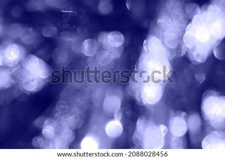 Festive shiny background with tinsel bokeh. Color very peri