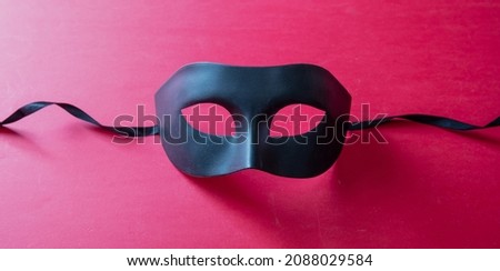 Carnival Venetian mask black on red color background. Traditional festival disguise, Mardi Gras masquerade
 Royalty-Free Stock Photo #2088029584