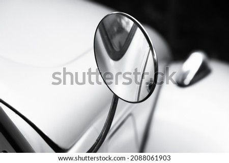 Round rearview mirror in chromed frame. Vintage car fragment, close up photo with selective soft focus