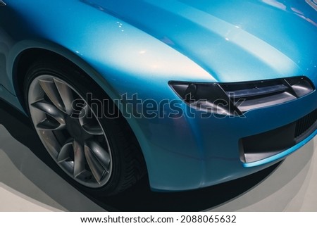 Headlight and wheel of a luxury blue roadster, conceptual sports car design elements Royalty-Free Stock Photo #2088065632