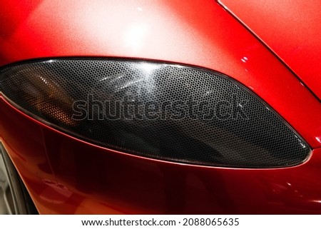 Headlight of a luxury red roadster, conceptual sports car design elements, close up photo Royalty-Free Stock Photo #2088065635