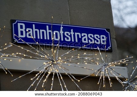 Road sign with text Bahnhofstrasse at famous shopping mile at City of Zürich on a rainy winter morning. Photo taken December 8th, 2021, Zurich, Switzerland.