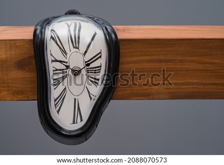 Melting clock on grey background