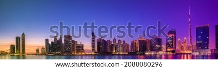 Cityscape of Dubai and panoramic view of Business bay with reflection of skyscrapers on water during purple sunrise, UAE Royalty-Free Stock Photo #2088080296
