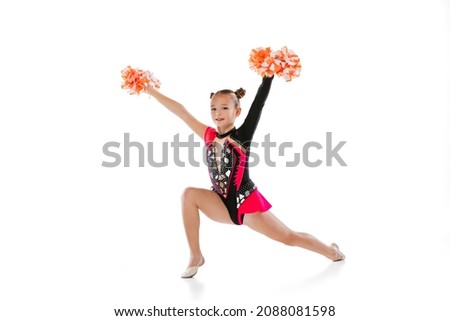 Portrait of girl, child, cheerleader in colorful costume with pom-pons training isolated lover white background. Concept of action, team sport game, energy, vitality. Copy space for ad.