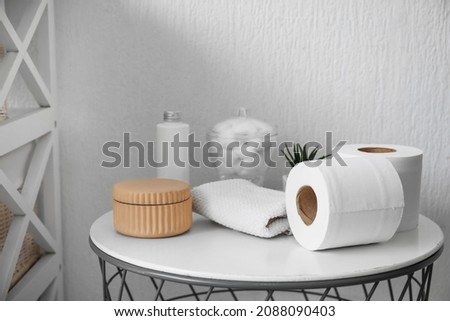 Rolls of toilet paper and bath supplies on table in bathroom Royalty-Free Stock Photo #2088090403