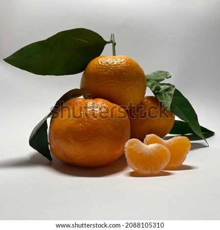 Tangerines on a white plate with two tangerine slices