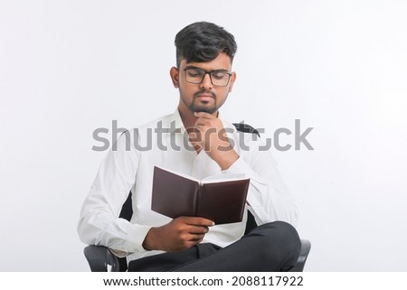 Young Indian male reading Diary over white background.