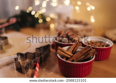 Home bakery, cooking traditional festive sweets. Cutting cookies of raw gingerbread dough on wooden table. New Year celebration traditions. Christmas mood