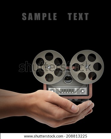 Analog recorder reel to reel Man hand holding object isolated on black background. High resolution 