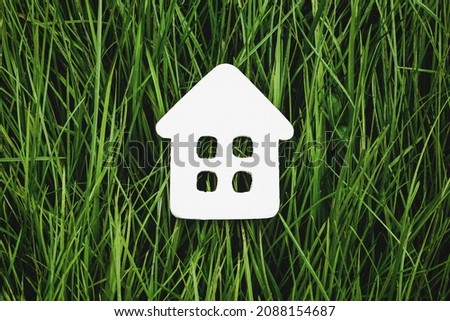 White paper house on green grass, sustainable living and eco-friendly housing
