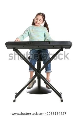 Little girl playing synthesizer on white background