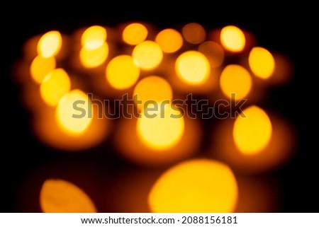Candle lights create a peaceful background of religious ceremony, defocused picture with a lot of free space.