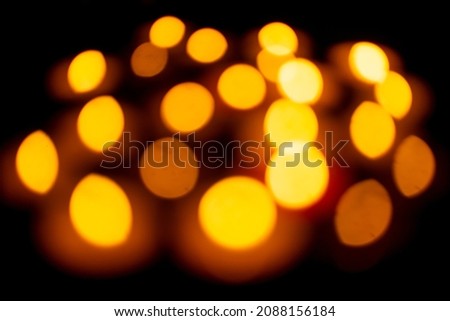 Candle lights create a peaceful background of religious ceremony, defocused picture with a lot of free space.