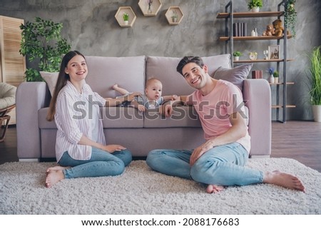 Photo of cheerful daddy mommy babysitting little boy wear casual outfit in comfortable apartment home indoors