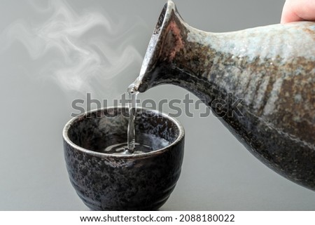 An image of pouring Japanese "liquor" into a bowl. Royalty-Free Stock Photo #2088180022
