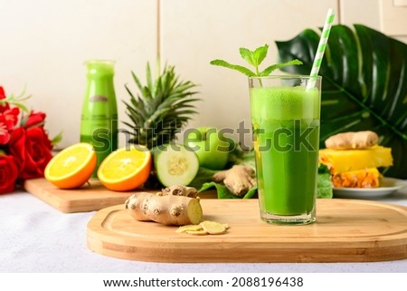 detox green juice, glass with green juice on a wooden board, small fruit ingredient for the juice next to the glass with the drink Royalty-Free Stock Photo #2088196438