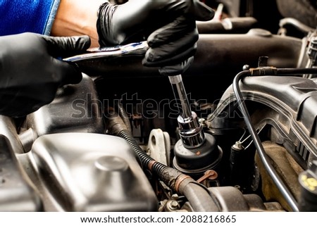 Hands with socket wrench ratchet. Changing car oil filter. DIY change engine motor oil. At home vehicle maintenance. Filter replacement. Oil filter cap Royalty-Free Stock Photo #2088216865