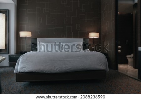 Elegant and comfortable home and hotel bedroom interior.There's a nice rug and a bedside lamp.