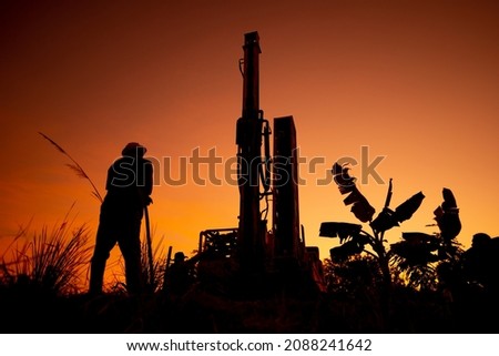 Working drill the artesian on sunset silhouette sky background, 
farmland in countryside or rural for drill the artesian on dirt ground, beautiful view landscape for working about soil technology Royalty-Free Stock Photo #2088241642