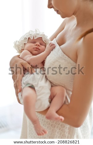 Mother and her Newborn Baby. Happy Mother and Baby kissing and hugging.  High key soft image of Beautiful Family. Maternity concept. Parenthood. Motherhood