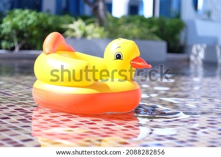 Baby yellow duck ring floating at the pool. 
