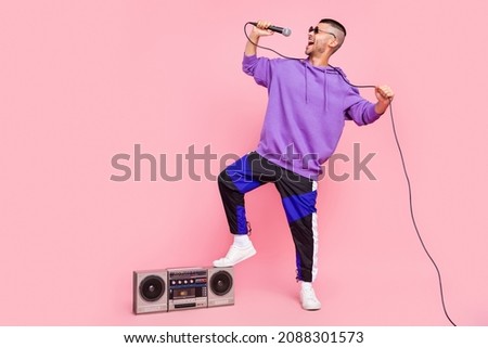 Full size photo of young man enjoy sing song microphone concert audio player isolated over pink color background