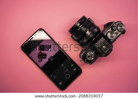 smartphone and mirrorless camera top view. phone camera control. modern photographer gadgets Royalty-Free Stock Photo #2088314017