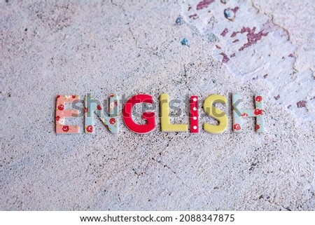 English word written with colorful letters on gray texture background 