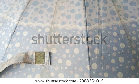 Picture of light blue dot pattern Small and large mixed on the umbrella cloth, old umbrella cloth background.