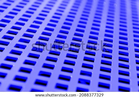 pattern background formed by a painted and perforated metal plate, selective focus
