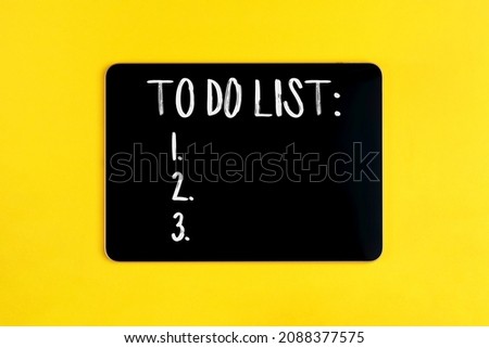 Black digital tablet with to do list on yellow background
