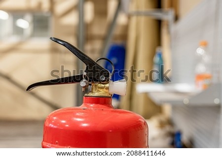 Small hand-held fire extinguisher with pressure gauge in a locksmith's shop.