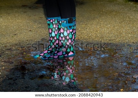 woman in colourful wellies stay in a puddle