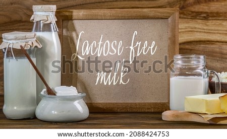 Lactose-free free-dairy products, mock-up frame. Bottles with milk, cheese, sour cream, butter on a wooden background. Fresh food Royalty-Free Stock Photo #2088424753