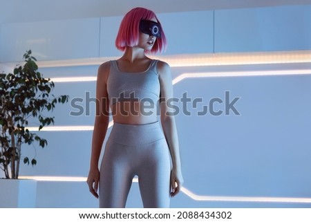 Woman in modern VR glasses interacting with network while having virtual reality experience. Augmented reality game, future technology, AI concept. VR. Holographic interface to display data.