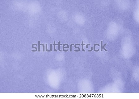 Abstract leaves shadow background with light bokeh toned in trendy Very Peri pantone color of the Year 2022, Abstract shadow background of natural leaves tree branch falling on wall and wallpaper text