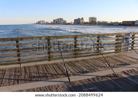 Fishing poles on pier with Jacksonville Beach in background