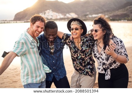 Group of happy multiracial friends having fun together on the beach, dancing and laughing. Mixed race people friendship concept. Multi ethnic students lifestyle. Real people emotions.
 Royalty-Free Stock Photo #2088501394