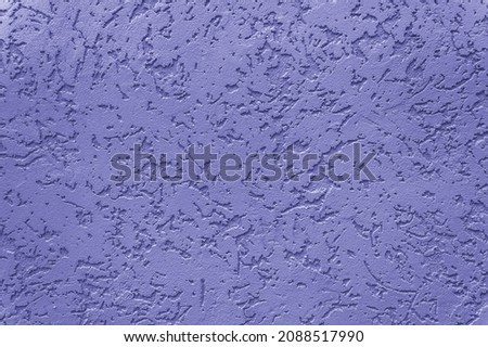 Textured concrete wall background toned in trendy Very Peri color of the year 2022. Decorative rustic coating. Abstract backdrop with rough stylized texture and copy space for text Royalty-Free Stock Photo #2088517990